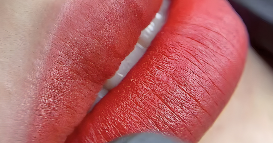 Close-up of a client having semi-permanent lip blush applied by a professional artist.