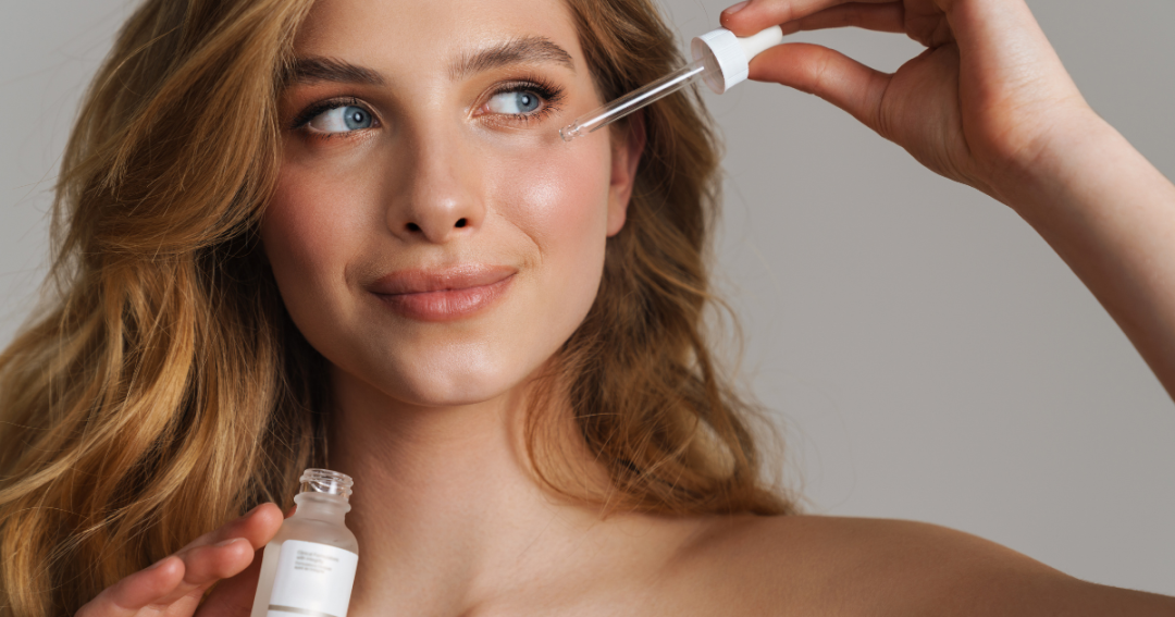Close-up of a patient gently massaging serum onto their face during a skincare treatment.