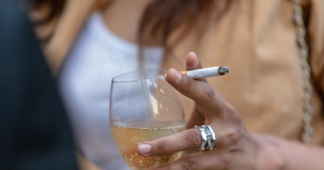 Smoker’s Lines: Causes, Prevention, and How Dermal Fillers Can Help 1 Individual holding a lit cigarette, exhaling a cloud of smoke.