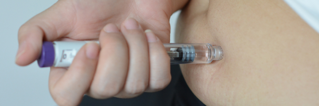 Patient self-administering a Mounjaro tirzepatide pen into the abdomen at home.