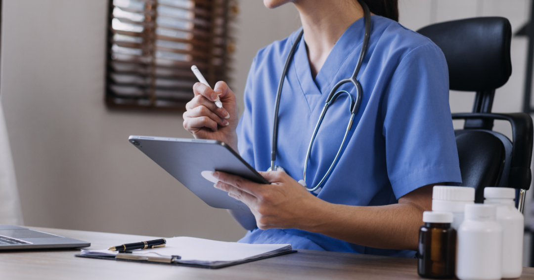 Top Benefits of Using a Booking System in Your Clinic 1 Nurse using a tablet to manage a digital patient booking system.