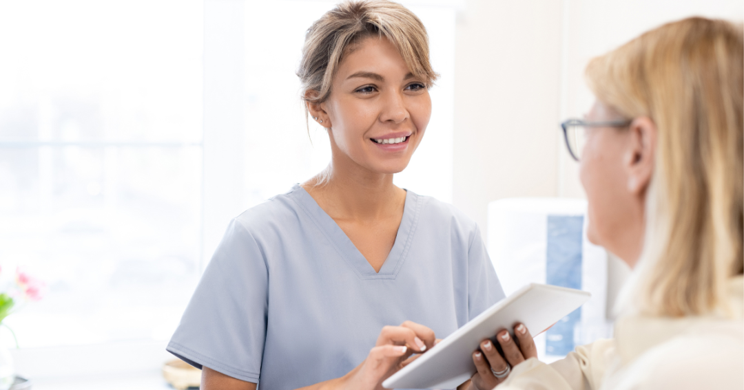 Faces | The Booking System Your Aesthetic Clinic Needs 2 Aesthetic practitioner using Faces in a tablet while consulting with a patient.