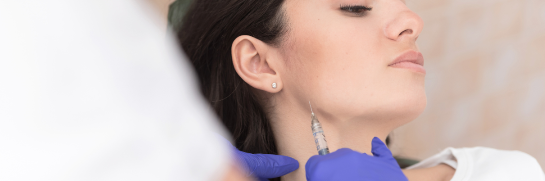 Client receiving a Botox injection in the masseter muscle of the jaw during an anti-wrinkle treatment.