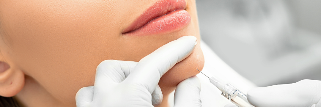 Gloved practitioner using a cannula to place dermal filler along the chin and jawline