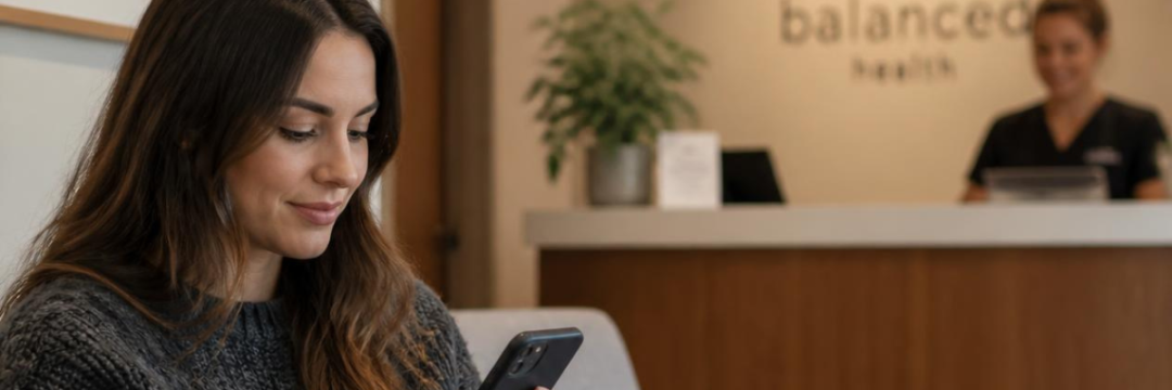 Alt text: "Client checking payment plan availability on her phone before booking an aesthetic consultation."
