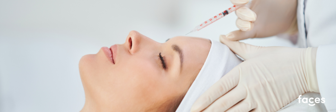 Practitioner administering a botulinum toxin injection to a client's forehead in a clinical setting