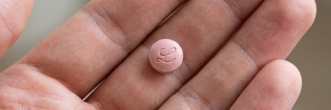 a patient holding a Foundayo pill