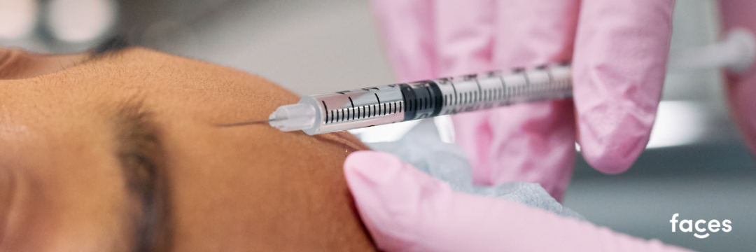 Aesthetic practitioner administering botulinum toxin injection to a client's forehead in a clinic.