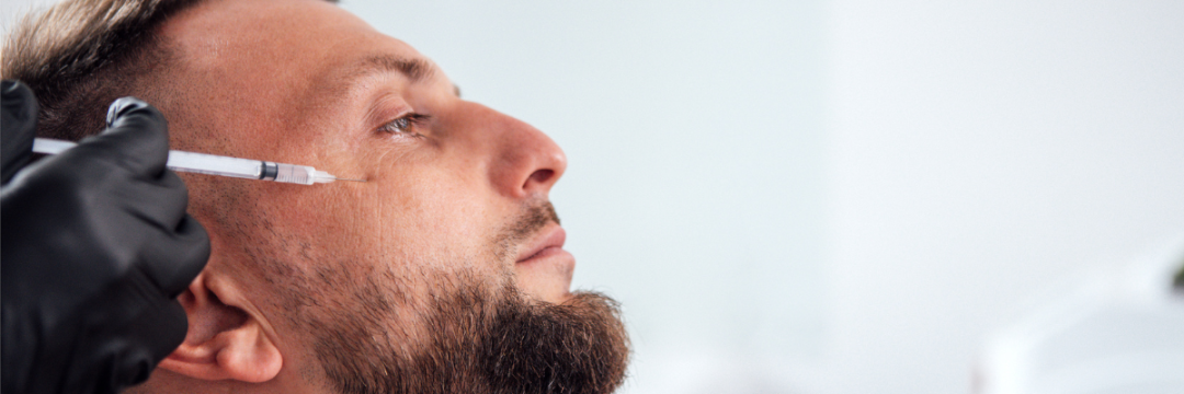 Male patient receiving a Botox injection to the forehead from a gloved practitioner in a clinic setting.